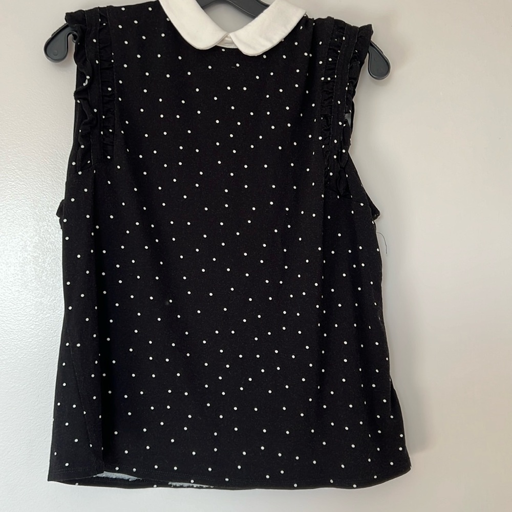 New. Women’s blouse sleeveless with raffled arm opening.